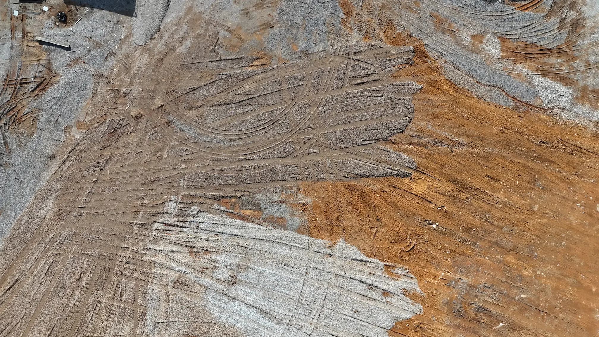 FAA Part 107 licensed aerial drone photograph of an active construction site captured by Alynto for a Southeast Tennessee contractor, showing graded pads, stockpiled material and equipment positions from above so the client can document progress for stakeholders and use the frame in project marketing.